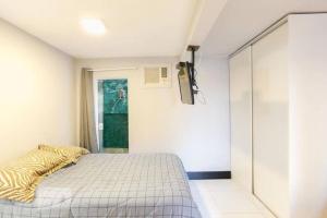 1 dormitorio con 1 cama y puerta corredera de cristal en Studio no Jabaquara a 2,8km da Expo imigrantes en São Paulo