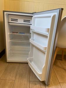 un frigorifero vuoto con la porta aperta in una cucina di 澎湖紙飛機民宿Paper Jet B&B a Magong