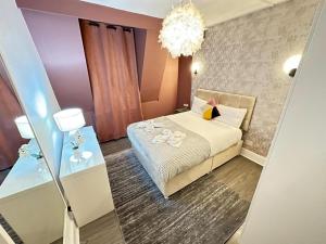 a small bedroom with a bed and a chandelier at Three Bedroom Near London Eye in London