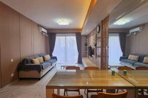 a living room with a table and a couch at Sky House BSD Apartemen T.Duxton in Tjilandak