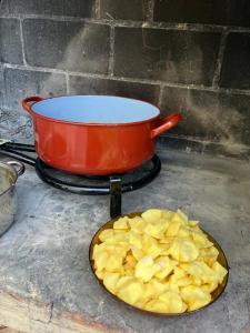 a pot on a stove with a plate of potato chips at El Rincón de Willy in Zazuar