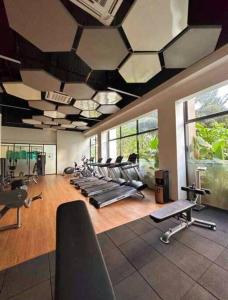 - une salle de sport avec de nombreux équipements d'exercice dans l'établissement Sky House BSD Apartemen T.Duxton, à Tjilandak