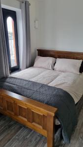 a bed with a wooden frame and a window at 1 main street athlone in Athlone