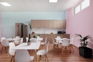 Local Hostel & Suites في مدينة كورفو: غرفة بها طاولات وكراسي ومطبخ