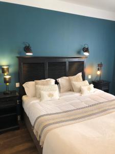 a bedroom with a large bed with a blue wall at Hotel Les Embruns in Le Touquet-Paris-Plage