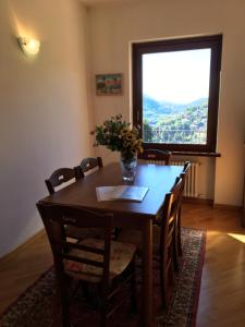una mesa de comedor con un jarrón de flores. en Appartamento Al Canelino - Como Lake and Mountains en Asso