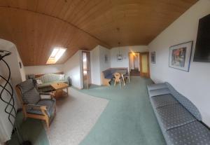 斯塔費爾湖畔穆爾瑙的住宿－Georgihof Ferienwohnungen，客厅配有沙发、椅子和桌子