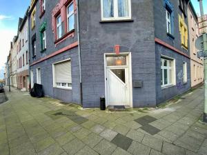 un edificio gris con una puerta blanca en una calle en Nice Apartment in Essen, en Essen