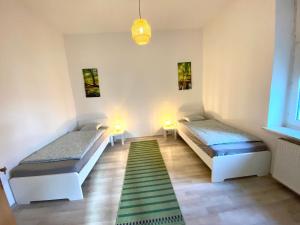 Habitación con 2 camas y alfombra verde. en Nice Apartment in Essen, en Essen