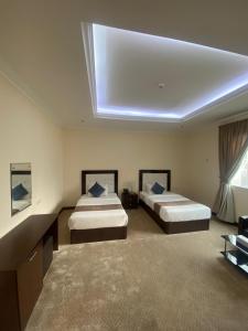 two beds in a large room with a skylight at A Line Hotel in Doha