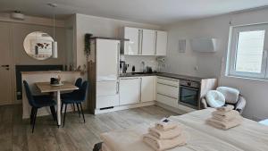 una cocina con una cama y una mesa con toallas. en Enny Suite Apartment im schönen Rheinland en Lohmar