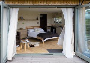 a bedroom with a bed and a sliding glass door at Daisy Bank Camp in Hebden Bridge