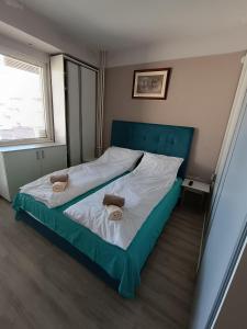 a bedroom with a large bed with two towels on it at Delfin Apartment in Bitola