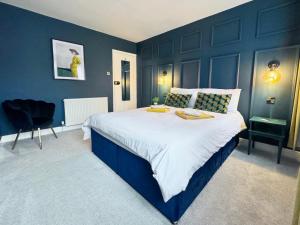 een slaapkamer met een groot bed met blauwe muren bij Stylish and Cosy stay in the Heart of Malton in Malton