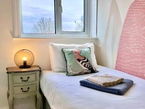 een slaapkamer met een bed met een kussen en een raam bij Stylish and Cosy stay in the Heart of Malton in Malton