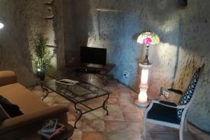 a living room with a table and a lamp at Maison atypique semi-troglodyte in Chinon