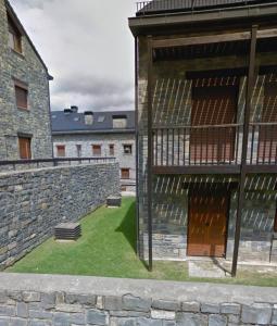 a courtyard with a stone wall and a building at Lunar in Castiello de Jaca