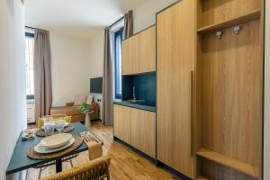a living room with a table and a kitchen at Palazzo Quantum 1 in Milan