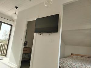 1 dormitorio con TV de pantalla plana en la pared en Chez Mimi 1,7 kilomètres de Luxeuil les Bains, en Froideconche