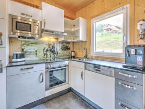 eine Küche mit weißen Schränken und einem Fenster in der Unterkunft Detached chalet in Hohentauern with sauna in Hohentauern