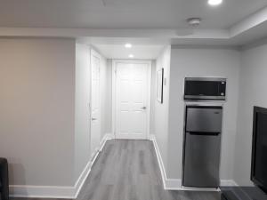 een witte kamer met een keuken met een fornuis en een magnetron bij Serene Niagara Guest House in Niagara Falls