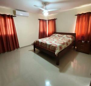 a bedroom with a bed and red curtains at Jarabacoa Villa Anchorage in Jarabacoa