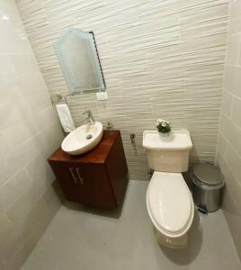 a bathroom with a white toilet and a sink at Jarabacoa Villa Anchorage in Jarabacoa