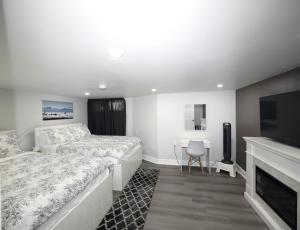een witte slaapkamer met een bed en een televisie bij Serene Niagara Guest House in Niagara Falls
