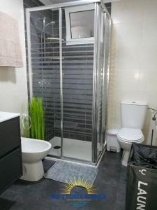 uma casa de banho com um chuveiro, um WC e um lavatório. em Apartamento Torre VII em Benidorm