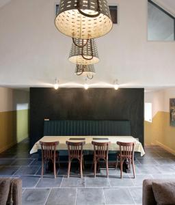 uma sala de jantar com uma mesa e cadeiras e um lustre em Creatively converted barn in accessible rural spot em Llanwrda