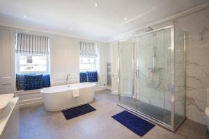 a bathroom with a tub and a glass shower at Elegant Georgian Maisonette - Central Bath in Bath