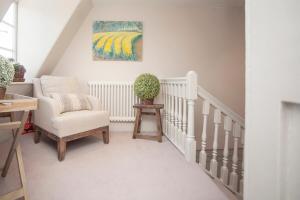 a living room with a chair and a painting at Elegant Georgian Maisonette - Central Bath in Bath