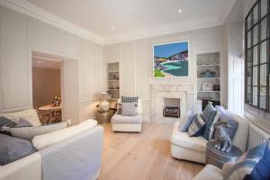 a living room with white furniture and a fireplace at Elegant Georgian Maisonette - Central Bath in Bath