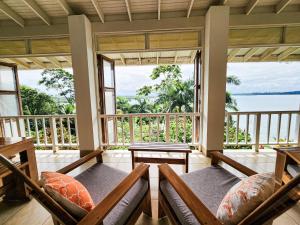 a screened in porch with a view of the ocean at Tropical Paradise, Oceanfront Home in the Jungle in Bocas del Toro