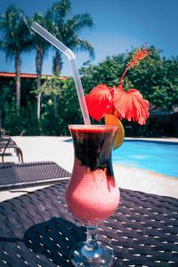 uma bebida com uma palha num copo sobre uma mesa em Ayla Praia Hotel em Porto Seguro