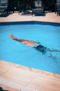 osoba pływająca w basenie z wodą w obiekcie Ayla Praia Hotel w mieście Porto Seguro