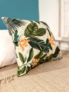 a pillow with a flower pattern on a bed at Alma Livre Pipa Casa de Praia in Pipa