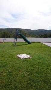 una diapositiva azul en medio de un campo de hierba en Casa Das Oliveiras, en Alvados