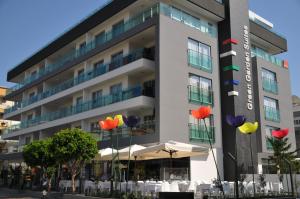 um edifício com guarda-chuvas coloridos à sua frente em Green Garden Suites Hotel em Alanya