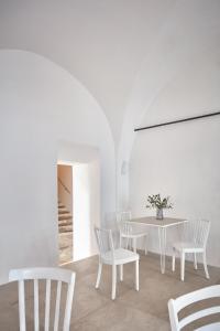 a white dining room with a white table and chairs at Stará Pekárna/Old Bakery in Znojmo