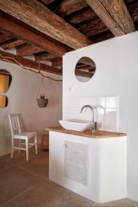 uma casa de banho branca com um lavatório e uma cadeira. em Stará Pekárna/Old Bakery em Znojmo