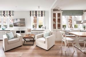 a living room with white chairs and a table at Altes Museum Haus 2 in Oevenum +21 photos