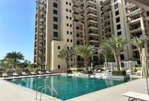 a swimming pool with palm trees and buildings at Lux BnB I Asayel I Burj Al Arab & Burj View in Dubai