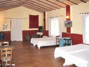 Cette chambre comprend 3 lits, une table et des chaises. dans l'établissement 6 bedrooms villa with private pool enclosed garden and wifi at Villanueva del Trabuco, à Villanueva del Trabuco