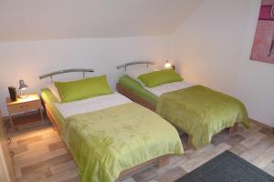 2 Betten in einem Zimmer mit grüner und weißer Bettwäsche in der Unterkunft Ferienwohnung Uni Koblenz in Koblenz