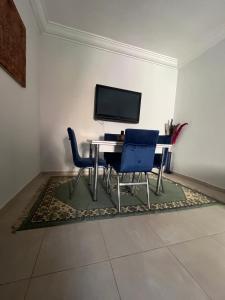 une salle à manger avec une table, deux chaises et une télévision dans l'établissement Appartement aéroport Marrakech, à Marrakech