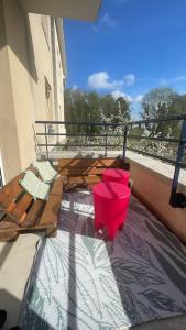 a balcony with a table and red buckets on it at Appartement entier Paris/Disney in Champs-sur-Marne