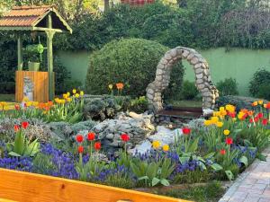 Villa Boyana City & Relax في صوفيا: حديقة بها قوس حجري وزهور