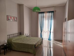 1 dormitorio con cama y ventana grande en Jolie, en Castellammare di Stabia