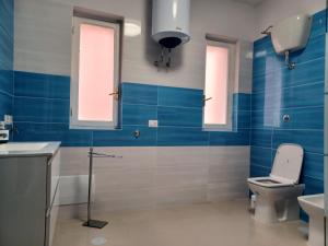 baño con aseo y lavabo y 2 ventanas en Jolie, en Castellammare di Stabia